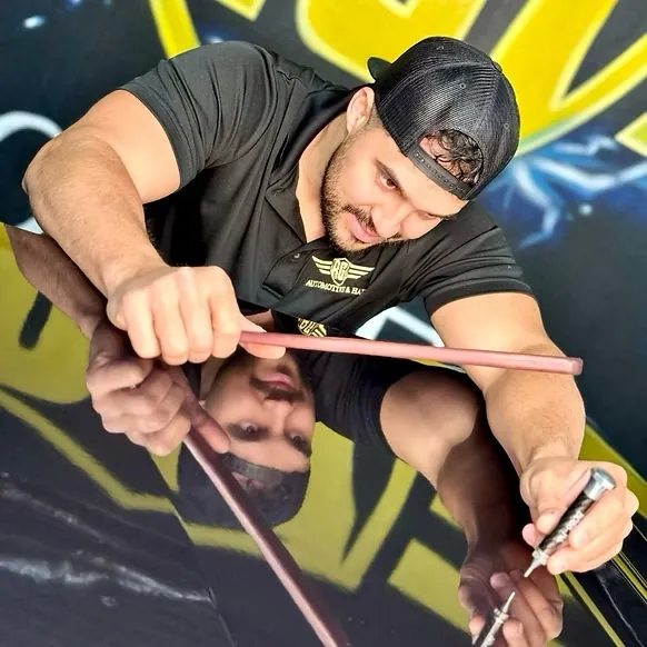 RG7 technician using a PDR rod on a mirror-finish car panel
