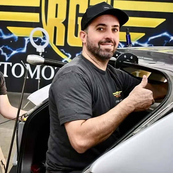 RG7 technician giving a thumbs-up from inside a car during repair
